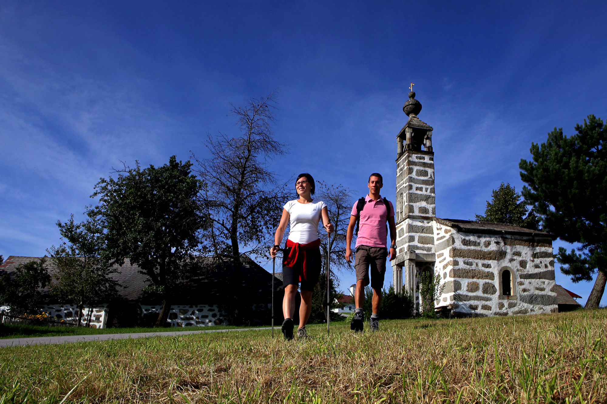 Zwei Wandernde im Sommer bei der Steinbloß Hoisnkapelle und dem steinbloßen Hoisnhaus